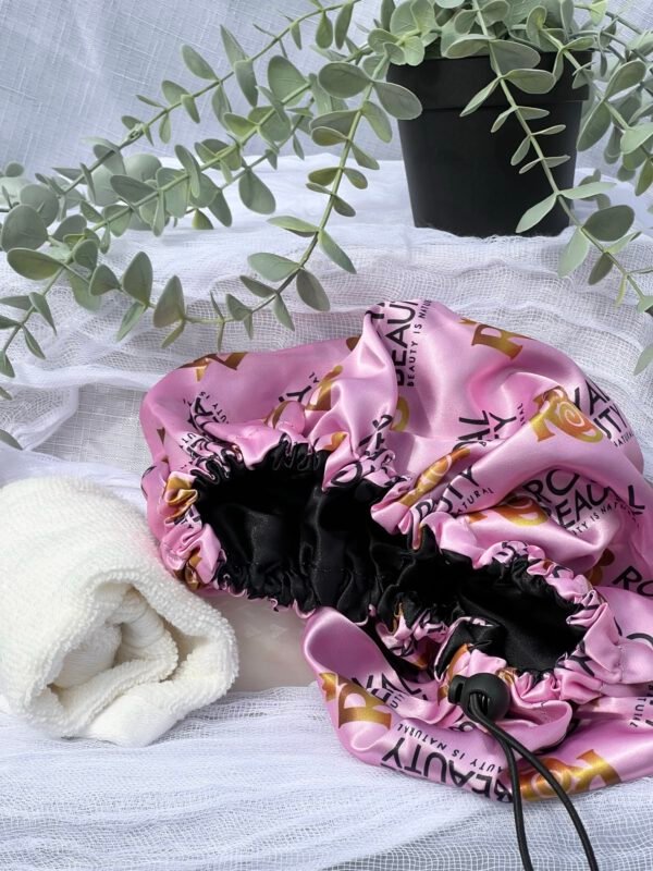 Pink Silk Hair bonnet with plant above it